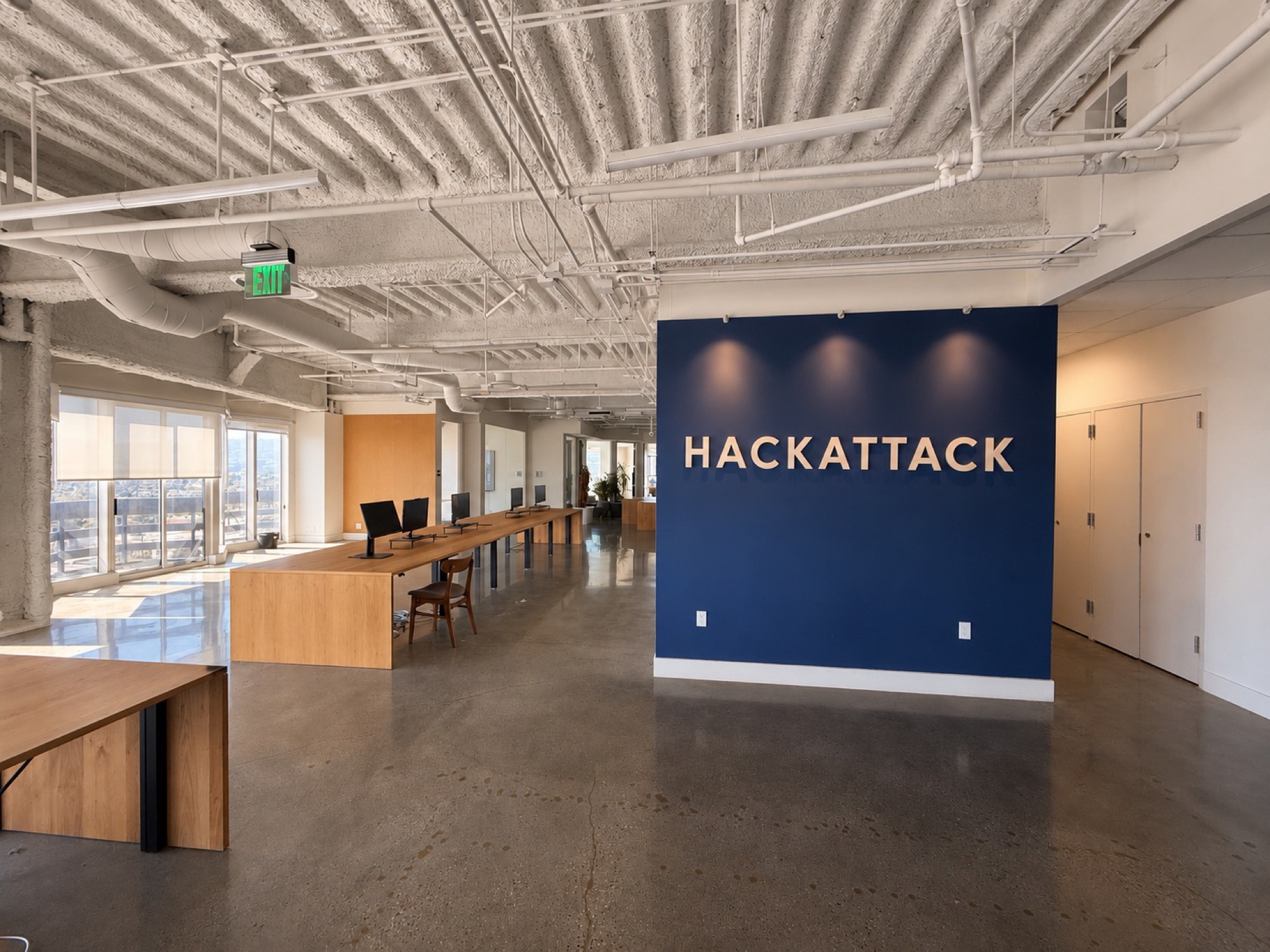 Open floor with the HACKATTACK wall and wraparound windows over Los Angeles